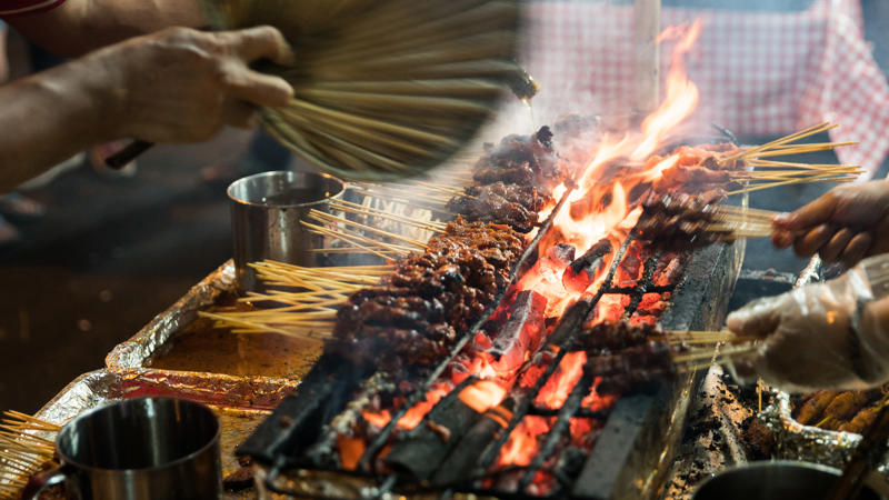 Una persona cocinando comida en una parrilla