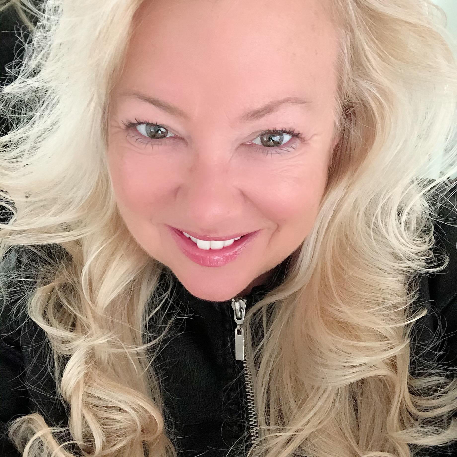 a person with blonde hair smiling
