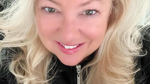 a person with blonde hair smiling