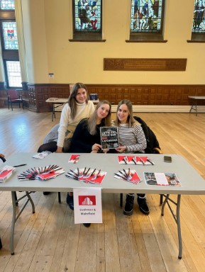 a group of women sitting at a table with a book