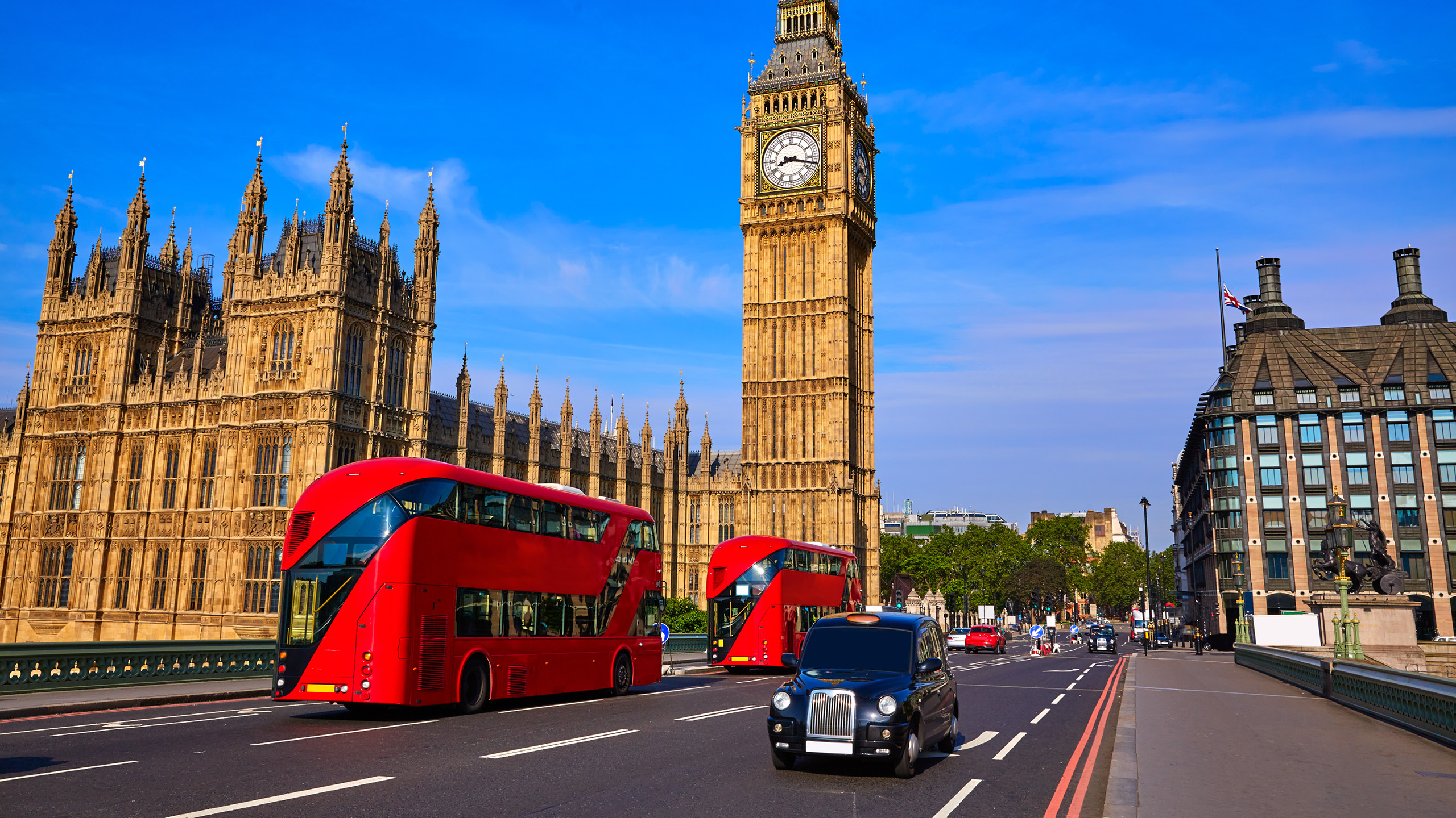 a double decker bus and a car on a street with a clock tower in the background