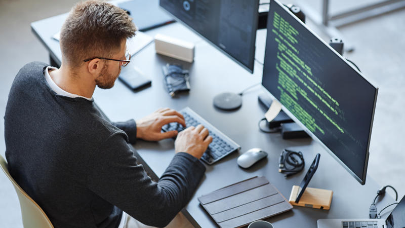 a person sitting at a desk using a computer