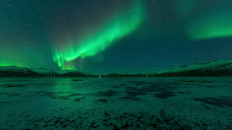 a green lights in the sky over a lake