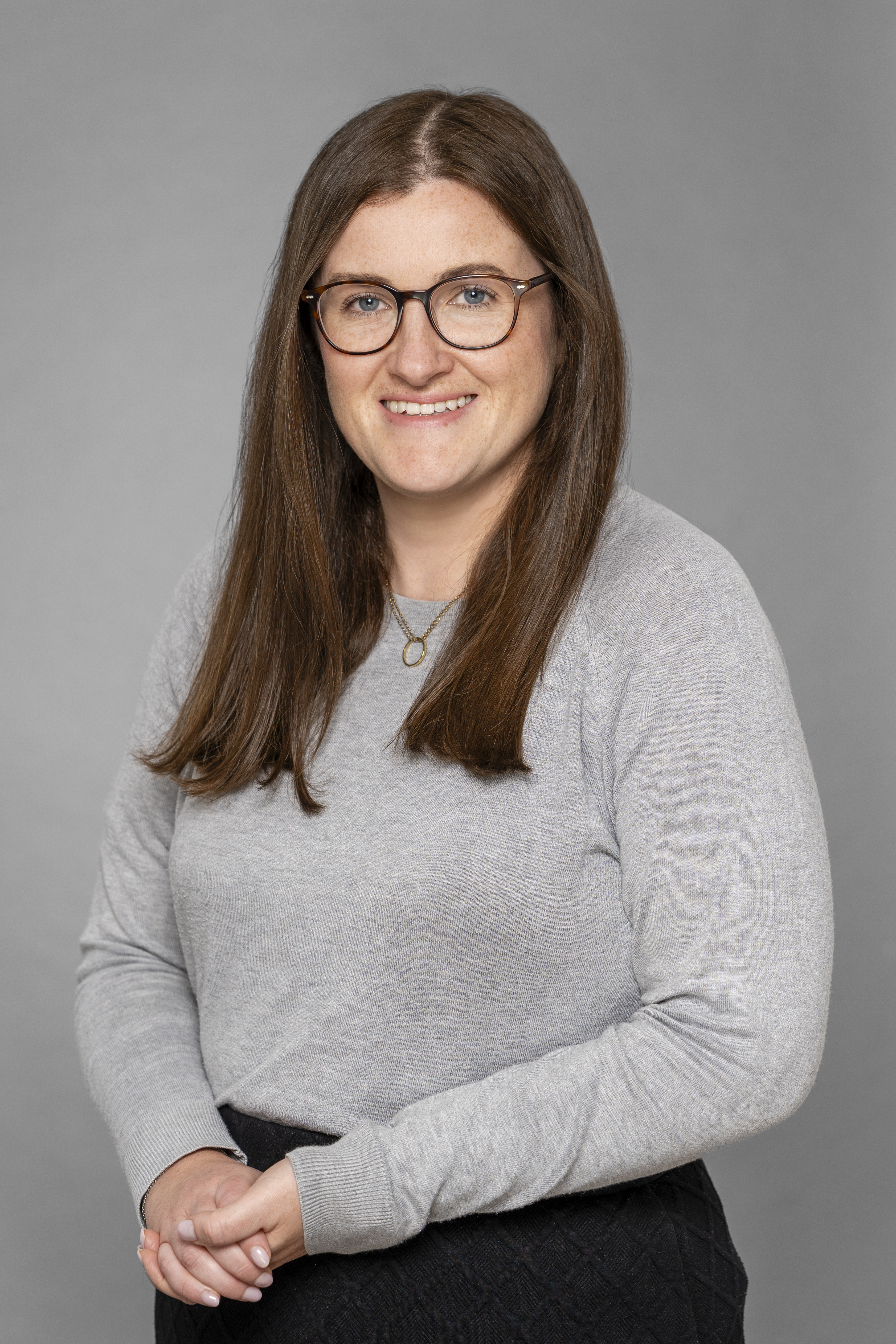 a person with long brown hair wearing glasses