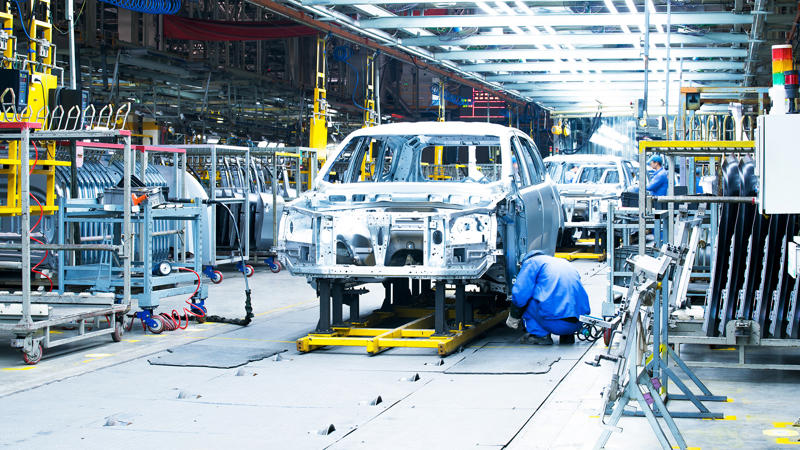 Un groupe de personnes travaillant sur une voiture dans une usine