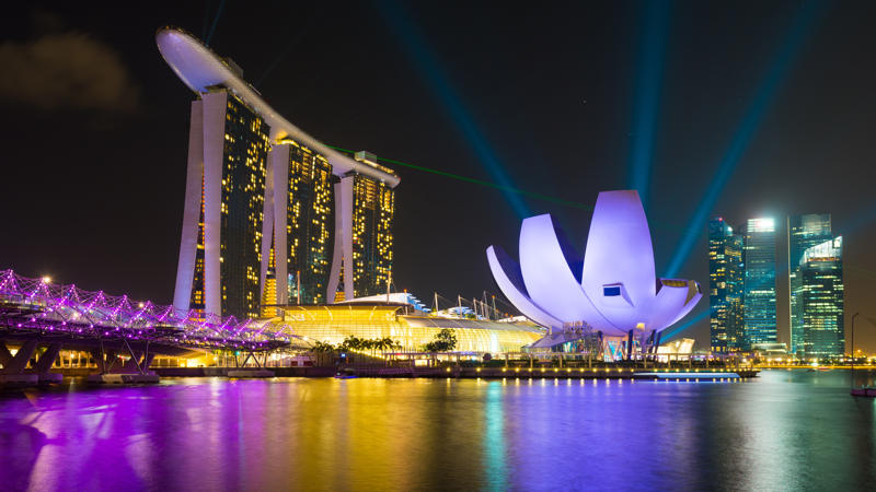 un horizonte de la ciudad con un cuerpo de agua y un edificio iluminado