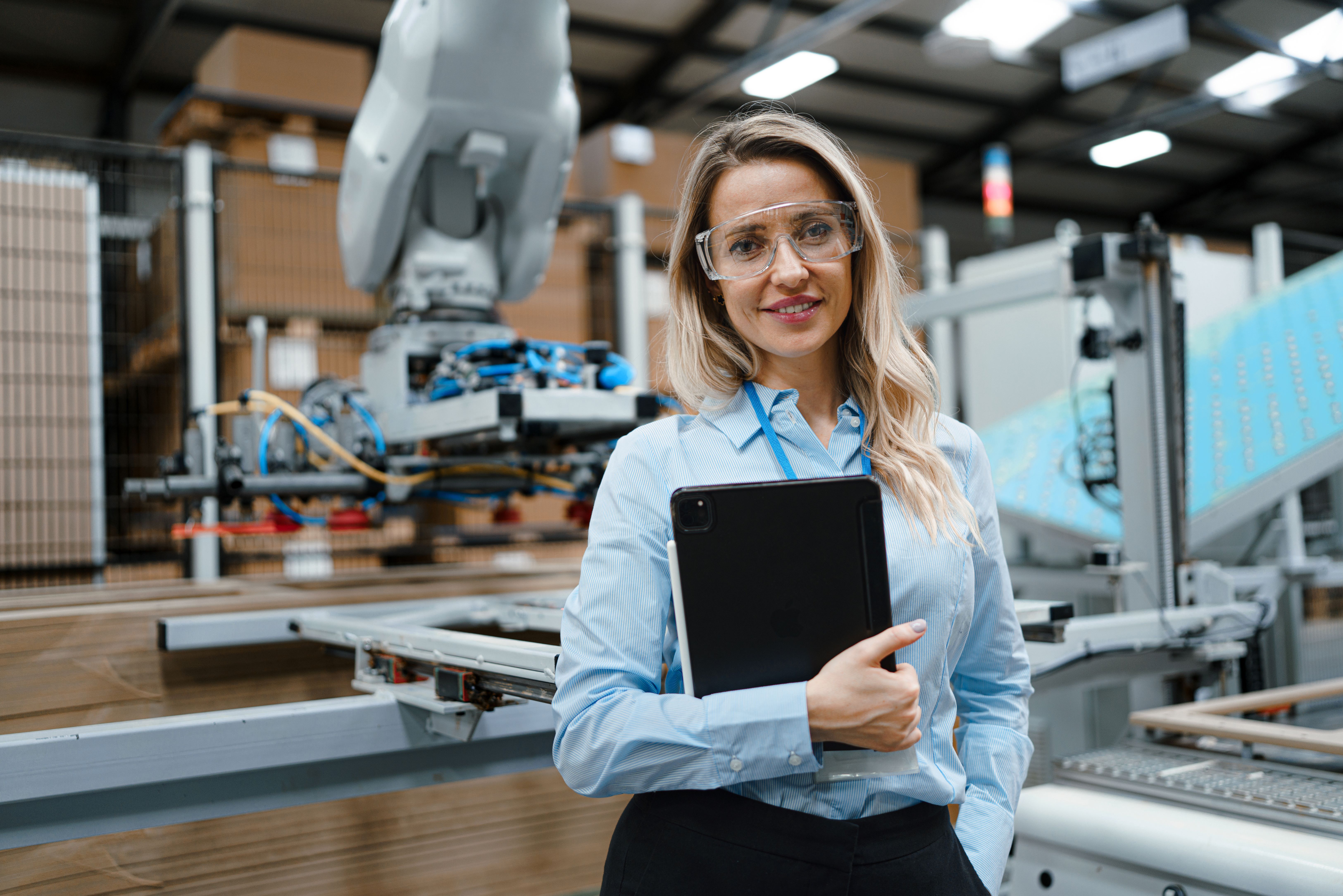 a person wearing safety goggles and holding a tablet