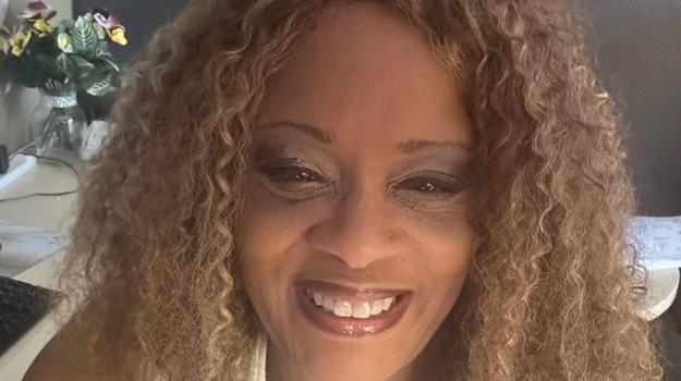 a person with curly hair smiling