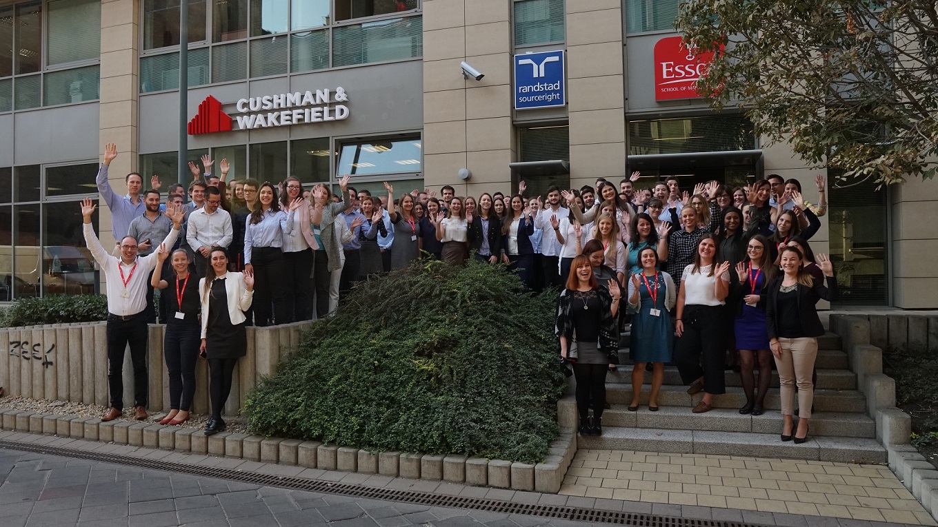Un grupo de personas de pie en los escalones frente a un edificio