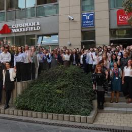 Un grupo de personas de pie en los escalones frente a un edificio