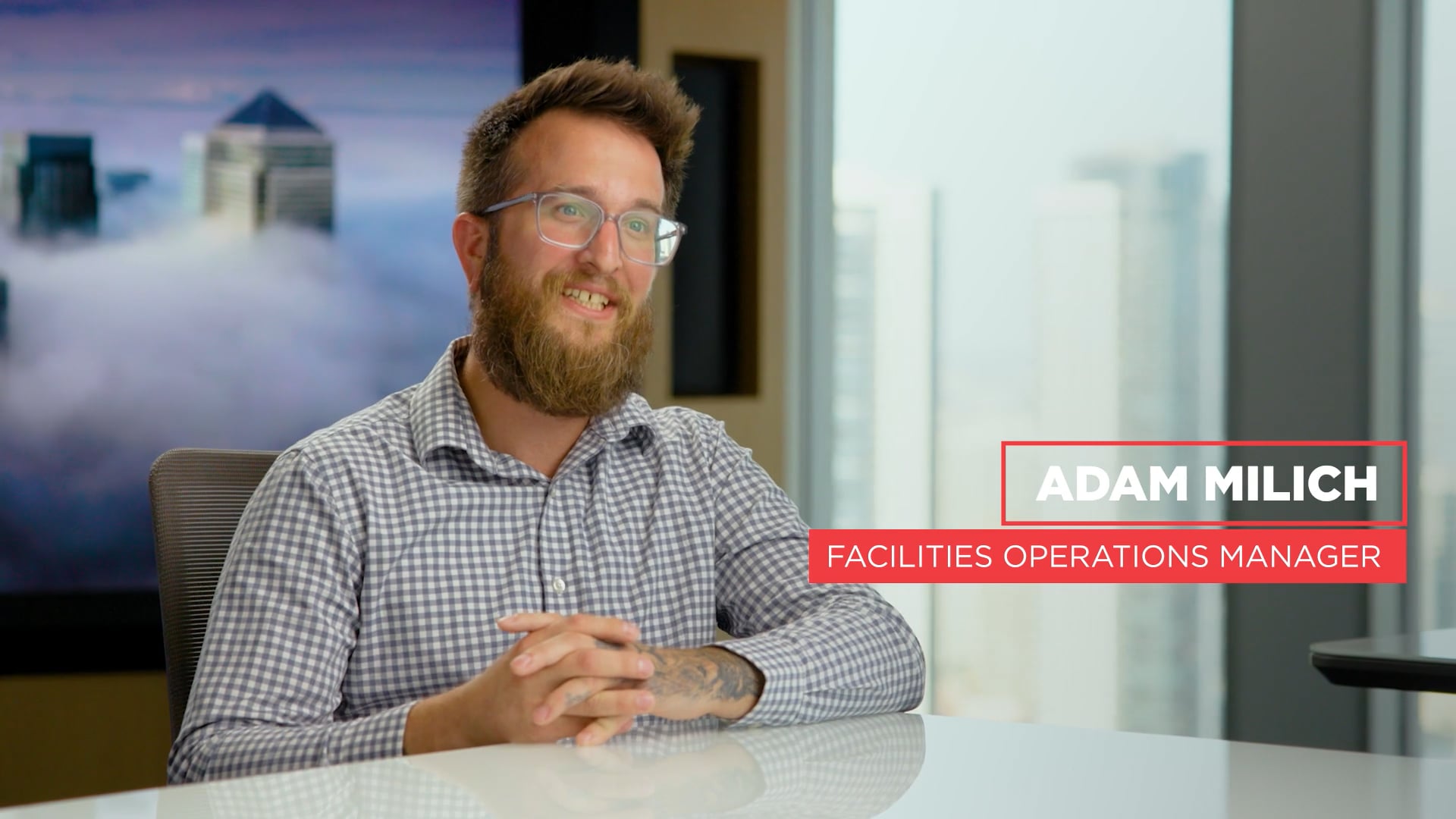 a person with a beard and glasses sitting at a table