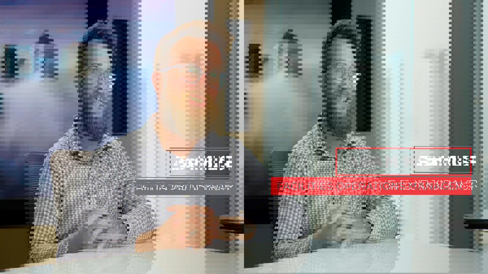 a person with a beard and glasses sitting at a table