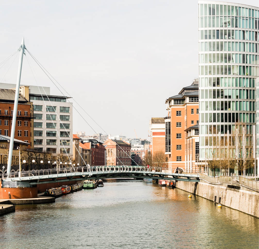 a river with a bridge and buildings
