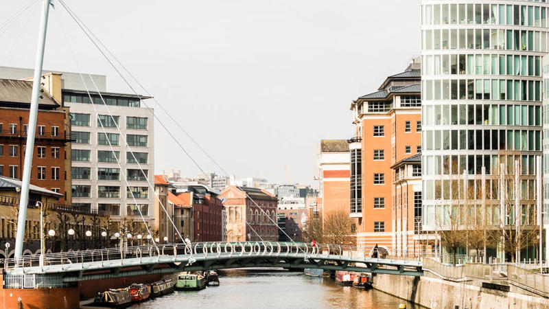 a river with a bridge and buildings