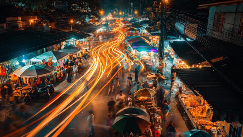 a street with people walking and cars with lights on