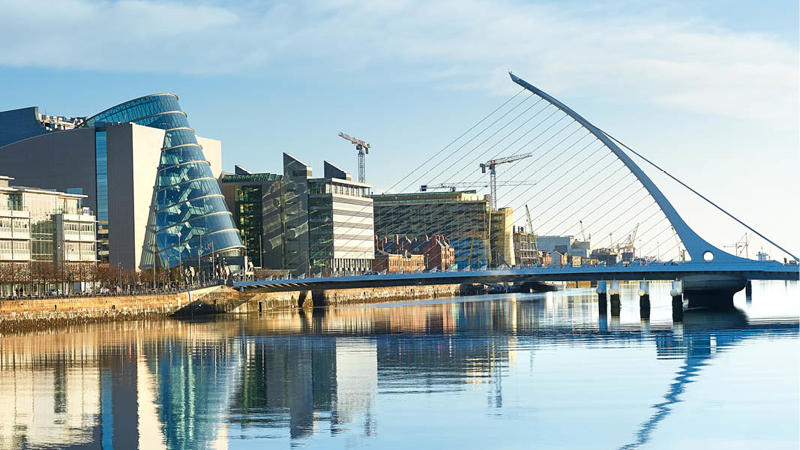 a bridge over water with buildings in the background