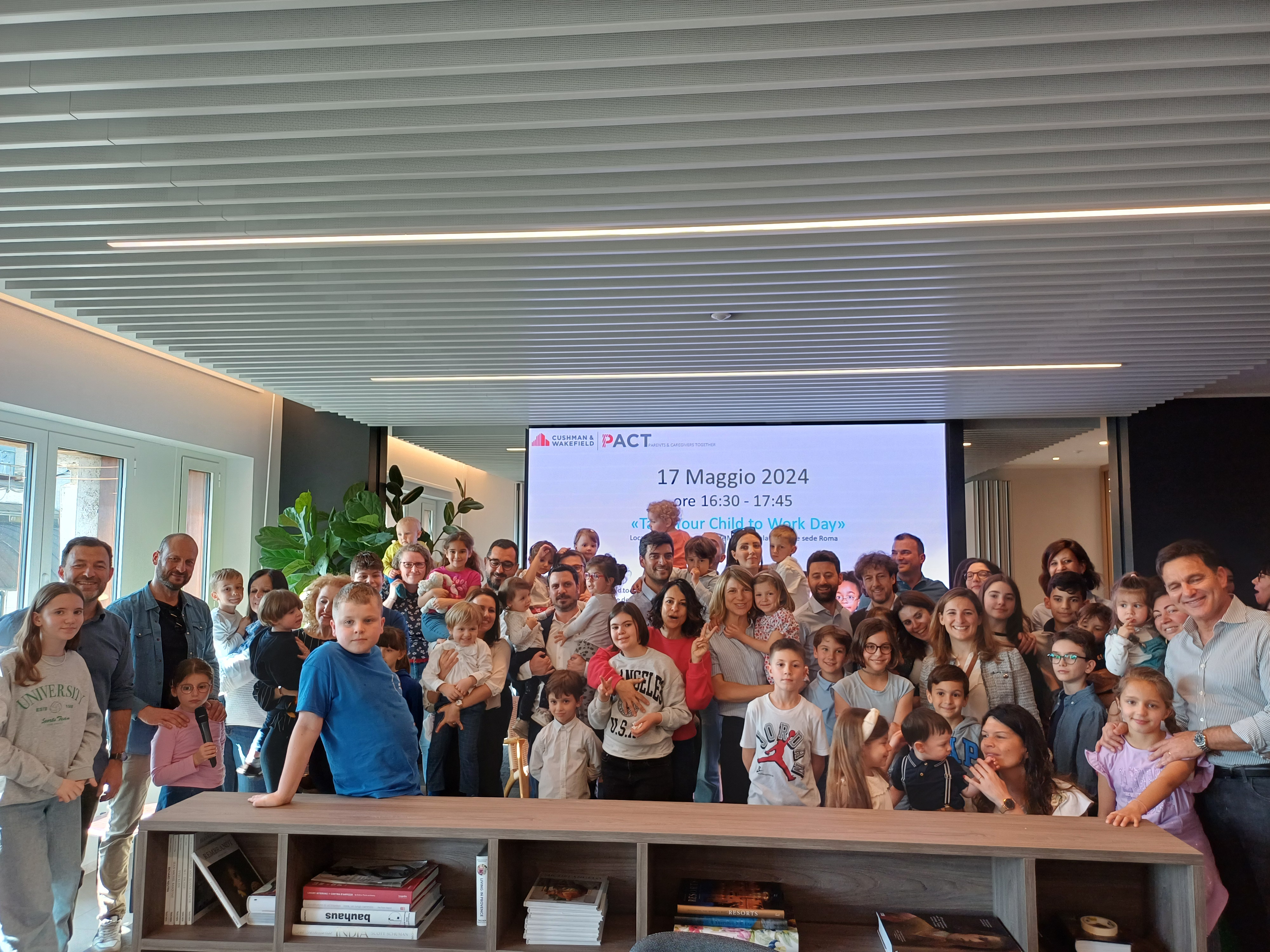 Un grupo de personas de pie frente a una pantalla