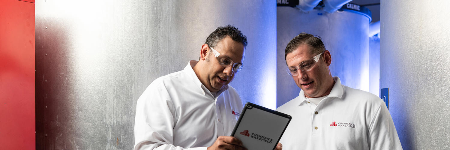 a couple of men looking at a tablet