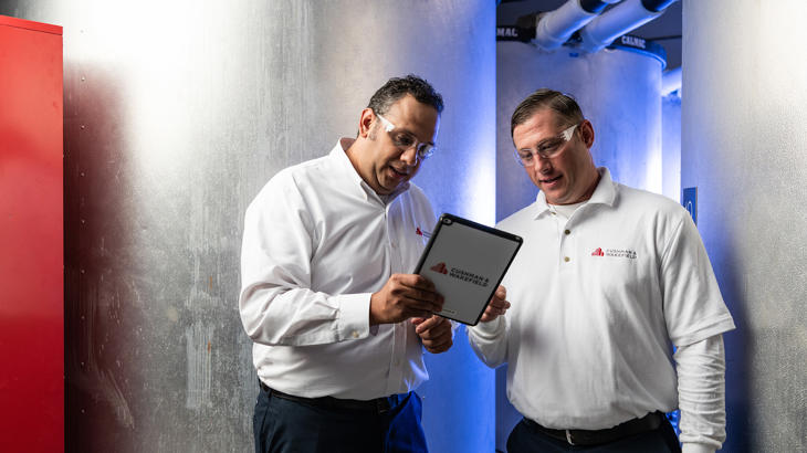 a couple of men looking at a tablet