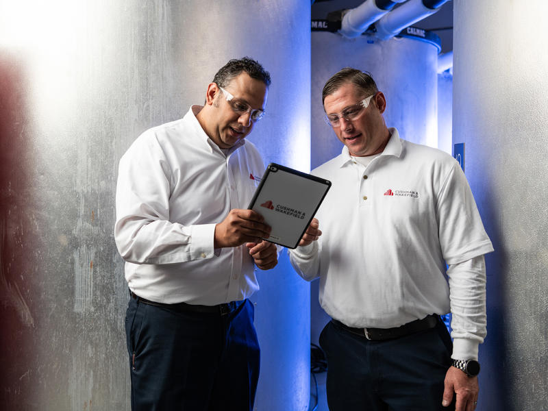 a couple of men looking at a tablet