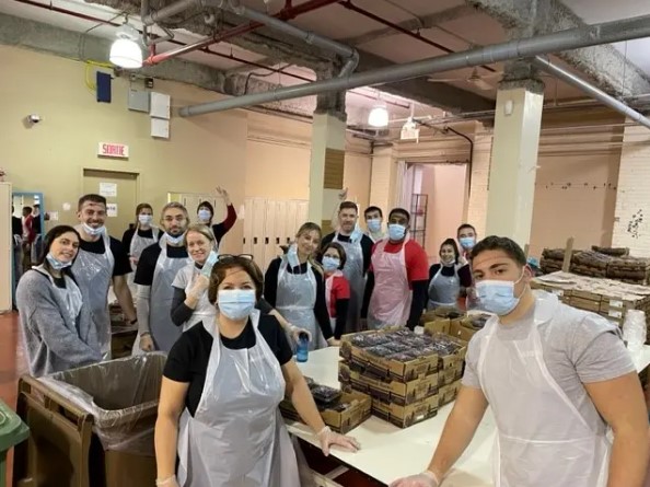 a group of people wearing masks and standing in a room with boxes