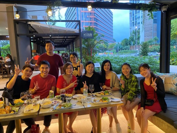a group of people sitting at a table with food