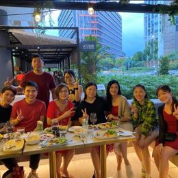 a group of people sitting at a table with food