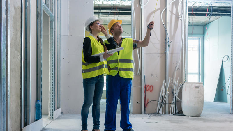 a person and person in safety vests and hardhats