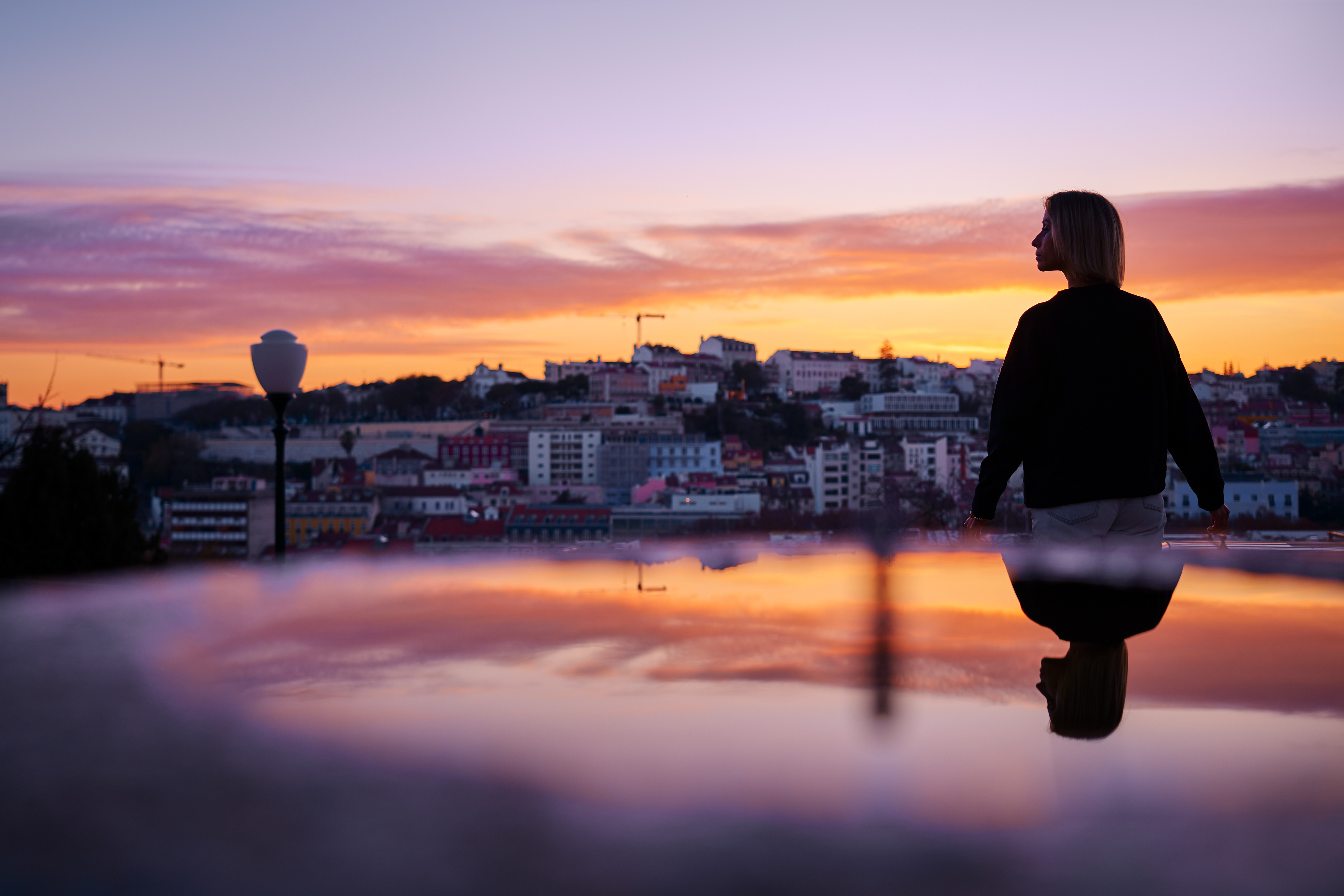 a person standing on a glass surface looking at a city
