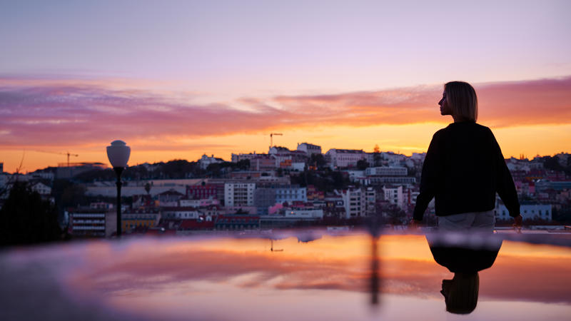 a person standing on a glass surface looking at a city
