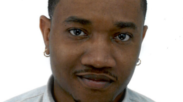 a person with short hair wearing earrings