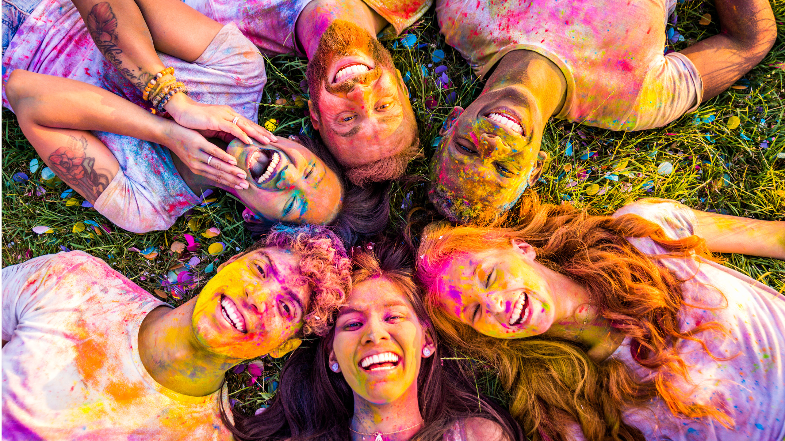 un groupe de personnes allongées en cercle avec de la peinture sur le visage