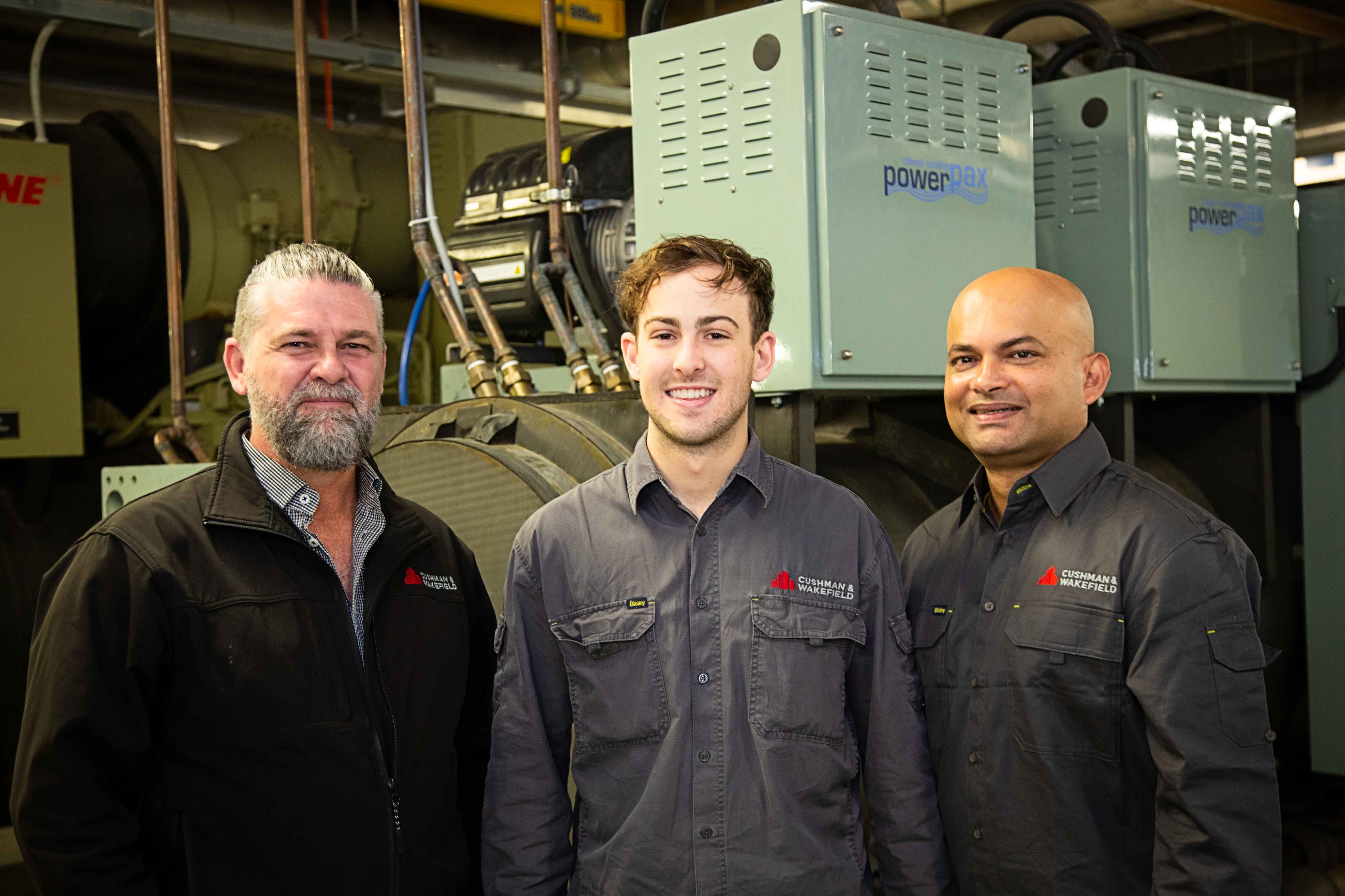 a group of men standing in front of machines