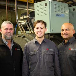 a group of men standing in front of machines