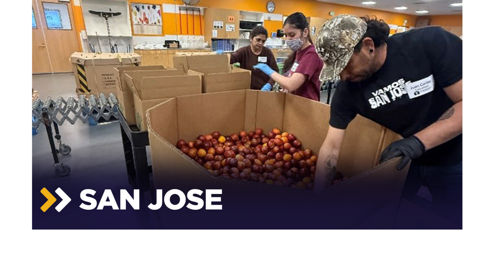 a group of people in a room with boxes of food