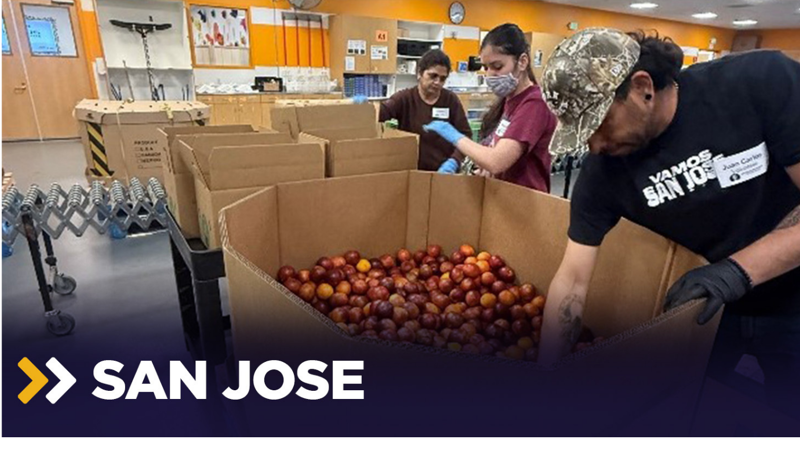 a group of people in a room with boxes of food