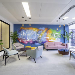 a room with a colorful wall mural and chairs