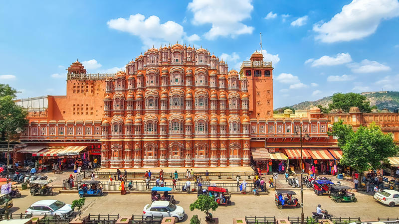 un grand bâtiment avec des fenêtres personnelles et une foule de personnes avec Hawa Mahal en arrière-plan